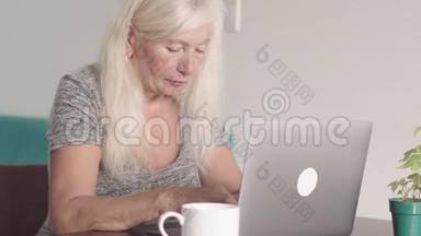 离退休老奶奶在家客厅用笔记本电脑特写镜头。 一位老年妇女正在购物